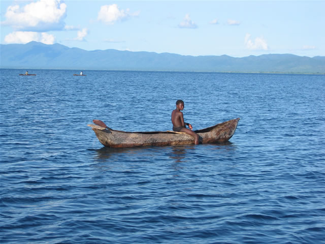 Jugendlicher Fischer auf seinem Holzboot