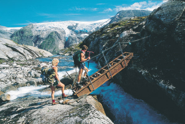 Breheimen Jotunheimen mountains mountain hiking couple crossing glacier stream on footbridge activity nature, Norwegen